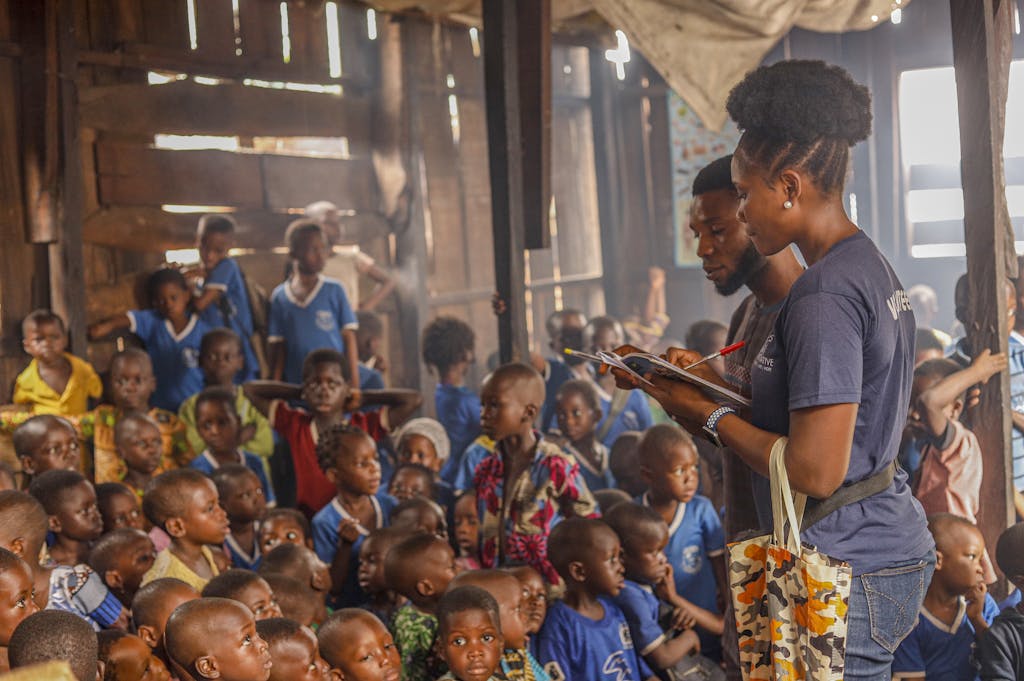 Volunteers conduct an educational session for children in an indoor community space.